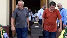 Люди выносят гроб с телом прихожанина Артемия, погибшего при нападении на храм Архангела Михаила в Грозном. 22 мая 2018 Люди выносят гроб с телом прихожанина Артемия, погибшего при нападении на храм Архангела Михаила в Грозном. 22 мая 2018
