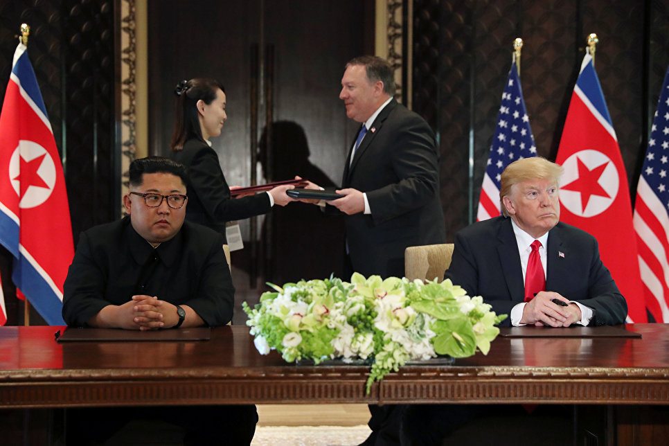 Лидер КНДР Ким Чен Ын и президент США Дональд Трамп во время подписания документов по итогам встречи в Сингапуре. 12 июня 2018