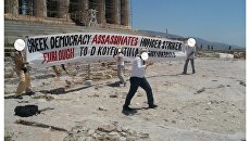 Анархисты из группировки Рубикон во время акции протеста у Акрополя в Афинах, Греция. 14 июня 2018 Анархисты из группировки Рубикон во время акции протеста у Акрополя в Афинах, Греция. 14 июня 2018
