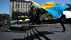 Молодой человек с украинским флагом. Архивное фото Молодой человек с украинским флагом. Архивное фото