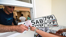 Выдача автовладельцу номерных знаков в одном из отделов регистрации транспортных средств ГИБДД по Москве. Архивное фото Выдача автовладельцу номерных знаков в одном из отделов регистрации транспортных средств ГИБДД по Москве. Архивное фото