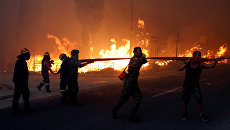 Пожарные во время борьбы с огнем в городе Рафина в Греции. 23 июля 2018 Пожарные во время борьбы с огнем в городе Рафина в Греции. 23 июля 2018