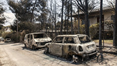 Сгоревшие в результате лесных пожаров автомобили на улице Мати в Греции. 25 июля 2018 Сгоревшие в результате лесных пожаров автомобили на улице Мати в Греции. 25 июля 2018