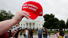 Кепка с надписью Make America Great Again у здания Белого дома в Вашингтоне, США. 2 августа 2018 Кепка с надписью Make America Great Again у здания Белого дома в Вашингтоне, США. 2 августа 2018