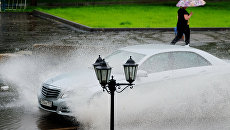 Автомобиль едет по улице Москвы во время дождя. Архивное фото Автомобиль едет по улице Москвы во время дождя. Архивное фото
