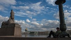 Молодой человек рисует на Университетской набережной в Санкт-Петербурге Молодой человек рисует на Университетской набережной в Санкт-Петербурге