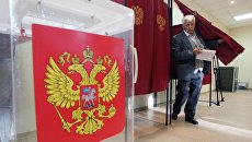 Избиратель голосует на избирательном участке. Архивное фото Избиратель голосует на избирательном участке. Архивное фото
