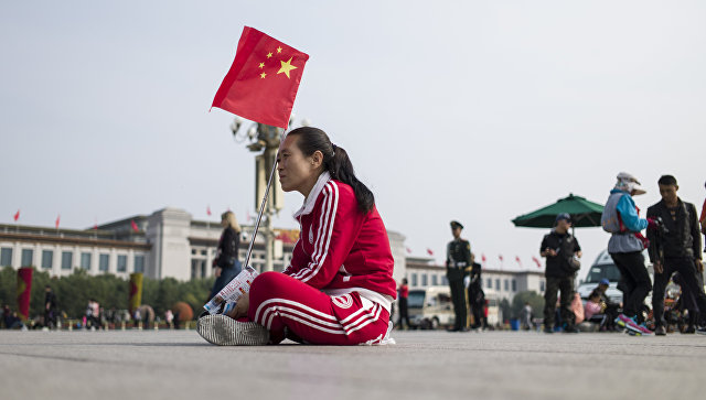 Женщина с флагом Китая на площади в Пекине. Архивное фото