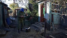 Сотрудник Совместного центра контроля и координации режима прекращения огня изучает последствия обстрела поселка Марьевка в Донецкой области. Архивное фото Сотрудник Совместного центра контроля и координации режима прекращения огня изучает последствия обстрела поселка Марьевка в Донецкой области. Архивное фото
