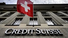 Флаг Швейцарии над вывеской банка Credit Suisse в Берне Флаг Швейцарии над вывеской банка Credit Suisse в Берне