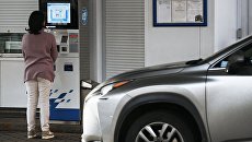 Женщина у терминала оплаты на автозаправочной станции. Архивное фото Женщина у терминала оплаты на автозаправочной станции. Архивное фото