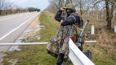Местный житель из отряда самообороны на блокпосте у въезда в аэропорт Бельбек, архивное фото Местный житель из отряда самообороны на блокпосте у въезда в аэропорт Бельбек, архивное фото